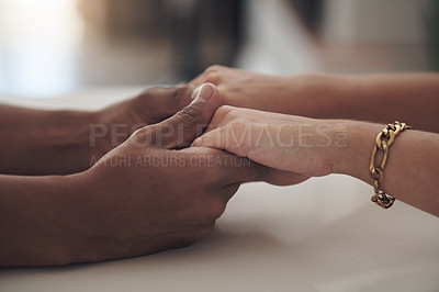 Buy stock photo Cropped shot of an unrecognizable couple sitting inside together and holding hands
