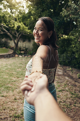 Buy stock photo Shot of an attractive young woman holding her boyfriend's hand and leading the way while on an outdoor date