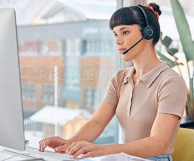 Buy stock photo Shot of a woman wearing a headset while working on her computer