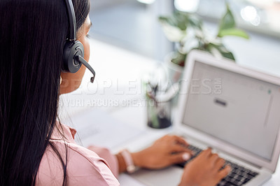 Buy stock photo Shot of a businesswoman wearing a headset while working on her laptop
