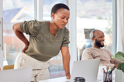Buy stock photo Shot of a businesswoman experiencing back pain while getting up from her desk