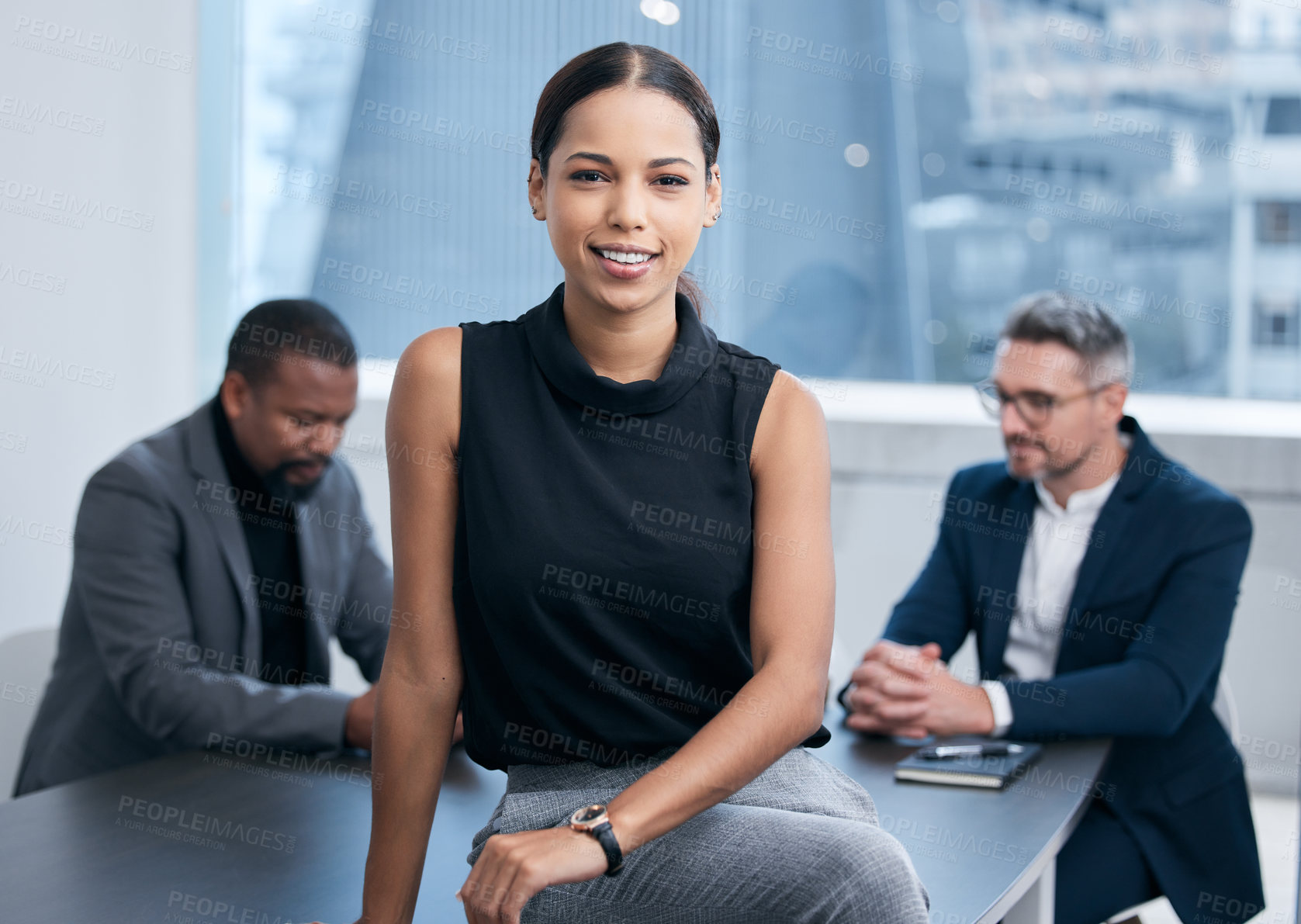 Buy stock photo Portrait of a confident young businesswoman standing in an office with her colleagues in the background