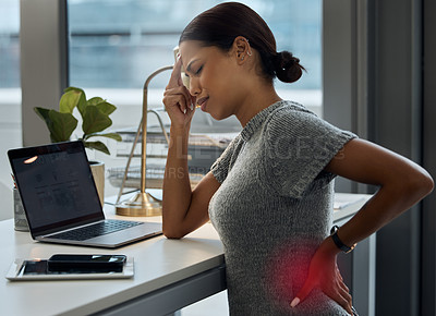 Buy stock photo Shot of a young businesswoman experiencing a headache and back pain in her office