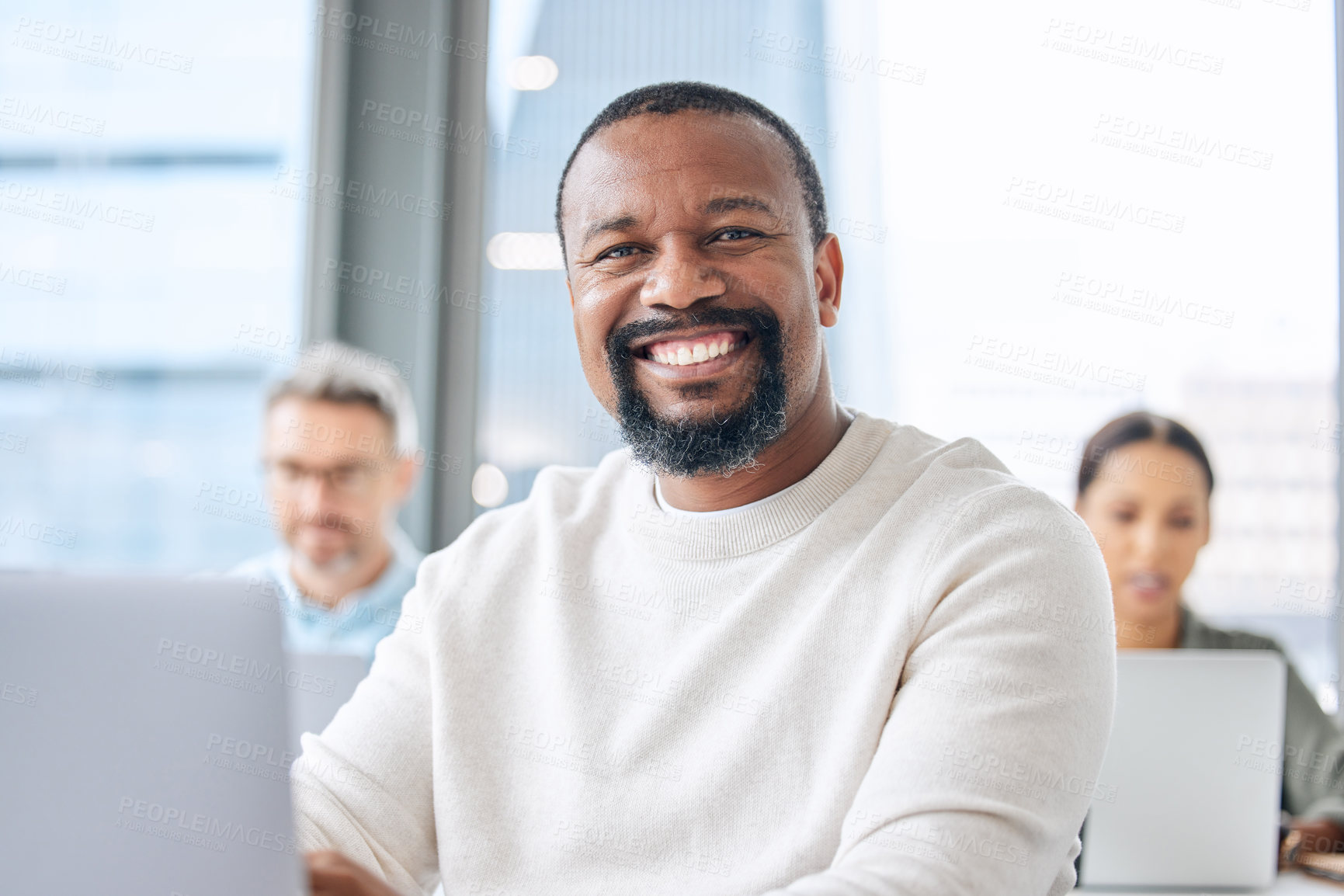 Buy stock photo Portrait of a mature businessman working on a laptop in an office