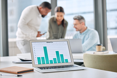 Buy stock photo Shot of a laptop with graphs on display in an office with businesspeople working in the background