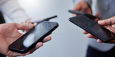 Buy stock photo Shot of a group of businesspeople using smartphones together