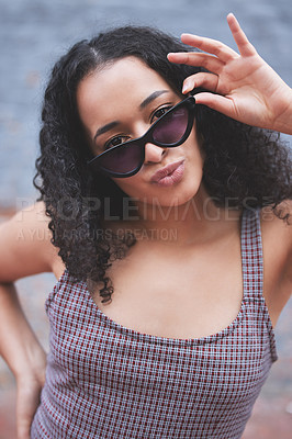 Buy stock photo Shot of a young woman wearing sunglasses while posing outside