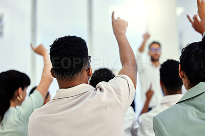 Buy stock photo Rearview shot of a group of unrecognizable businesspeople sitting with their hands raised while attending a seminar