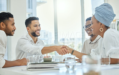 Buy stock photo Cropped shot of two young diverse businesspeople shaking hands during a meeting in the boardroom