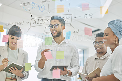 Buy stock photo Cropped shot of a group of diverse young businesspeople working on a glass wipe board in the boardroom