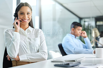 Buy stock photo Shot of a young call centre agent sitting in the office with a colleague and wearing a headset