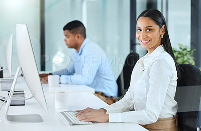 Buy stock photo Shot of a young call centre agent sitting in the office with a colleague and wearing a headset