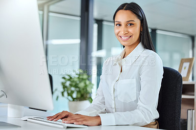 Buy stock photo Shot of an attractive young call centre agent sitting in the office and wearing a headset while using her computer