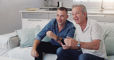 Buy stock photo Shot of a father and son duo watching tv together