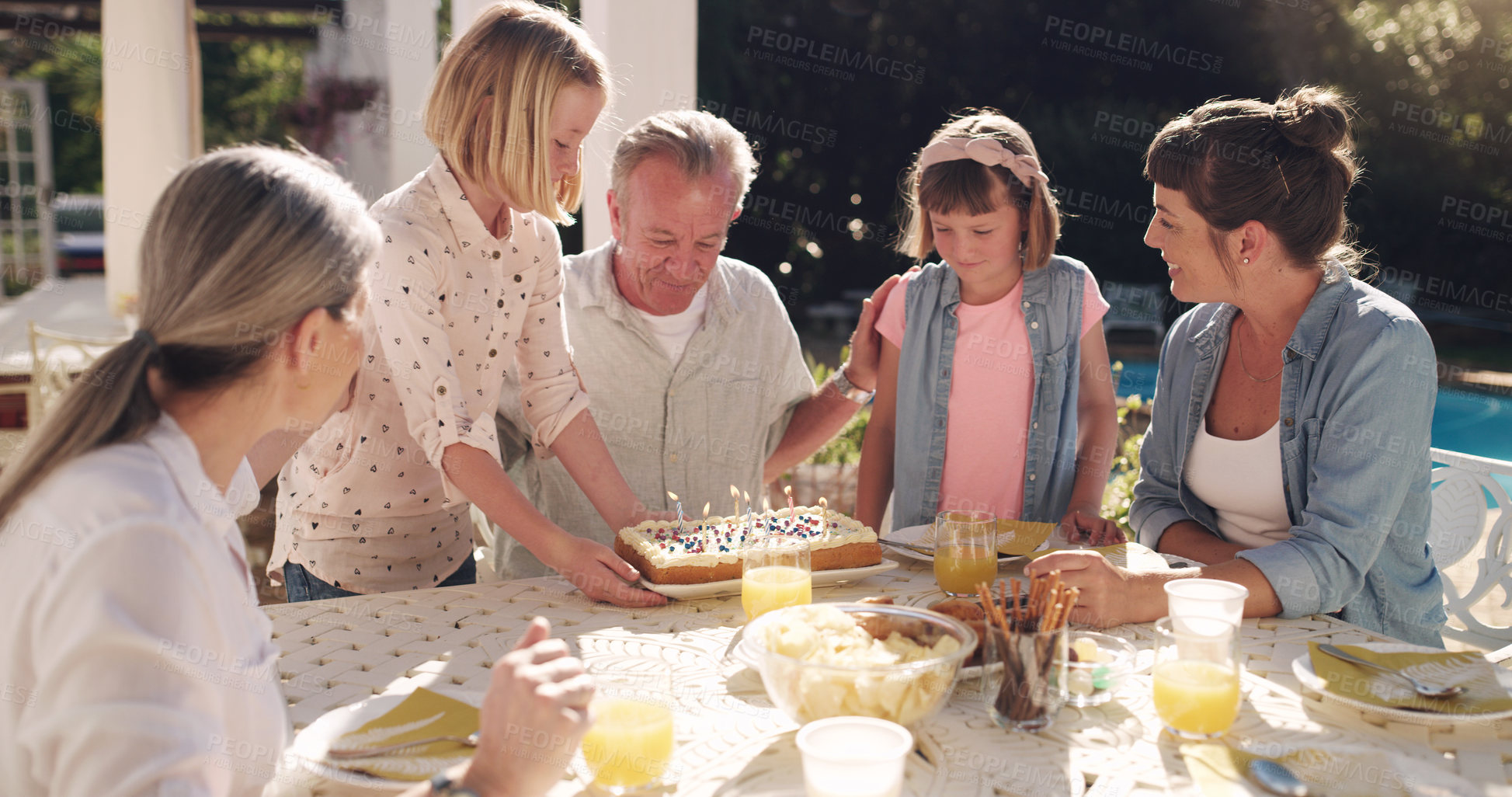 Buy stock photo Shot of a grandfather celebrating his birthday with his grandchildren at home