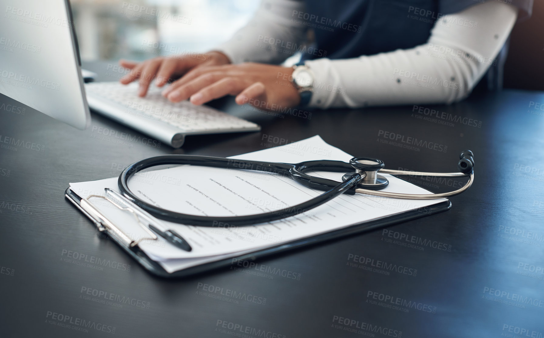 Buy stock photo Shot of an unrecognizable doctor using computer in an office