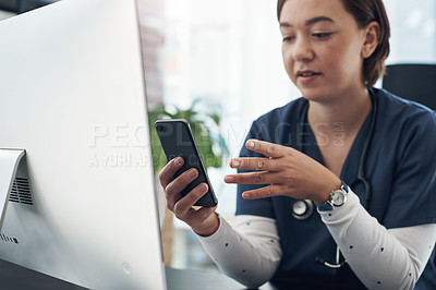 Buy stock photo Shot of a young doctor using a cellphone in an office