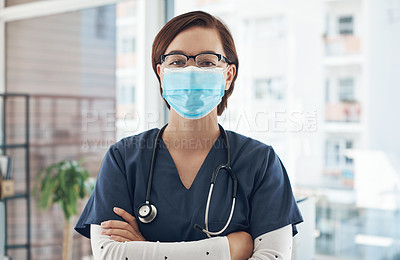 Buy stock photo Shot of a young doctor wearing a mask in an office
