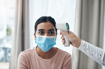 Buy stock photo Shot of an unrecognizable doctor using a thermometer to take a patient's temperature in an office
