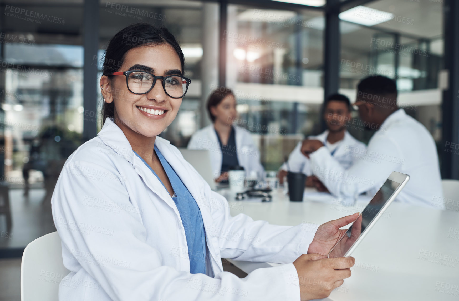 Buy stock photo Shot of a young female doctor using her digital tablet