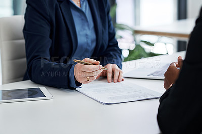 Buy stock photo Shot of an unrecognisable businesswoman filling out paperwork during a team meeting in a modern office