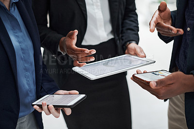 Buy stock photo Shot of a group of businesspeople using wireless devices during a meeting in a modern office