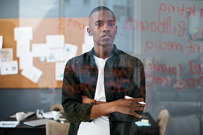 Buy stock photo Shot of a young businessman making notes in a modern office