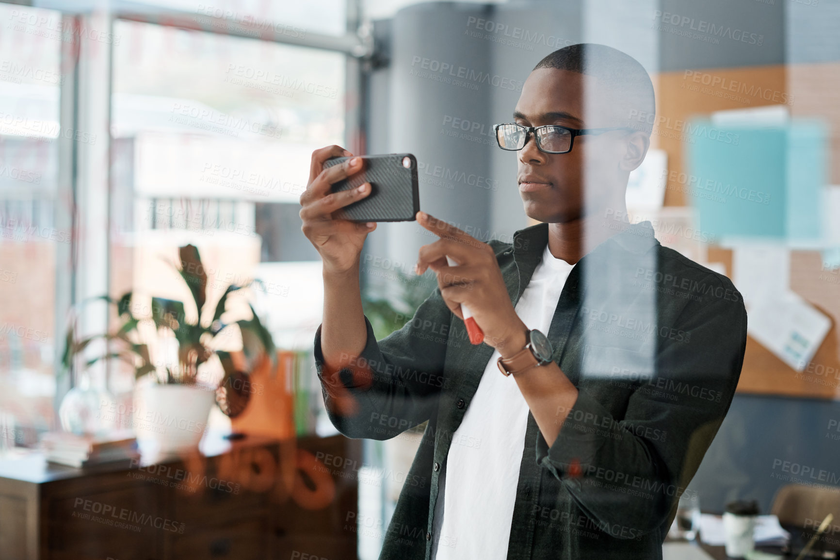 Buy stock photo Black man, phone and reading notes in office schedule, agenda and email for startup business. African, male person and scroll with website for review, feedback and notification of project proposal