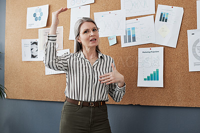 Buy stock photo Shot of a mature businesswoman doing a presentation in a modern office