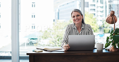 Buy stock photo Portrait of a mature businesswoman using her laptop in a modern office