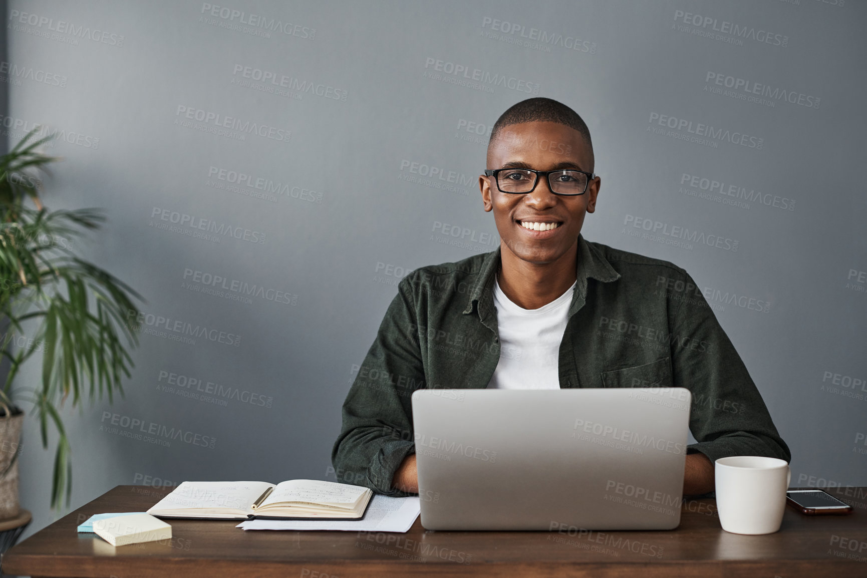 Buy stock photo Shot of a young businessman typing on his laptop