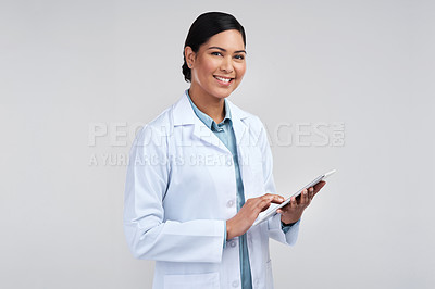 Buy stock photo Cropped portrait of an attractive young female scientist using a tablet in studio against a grey background