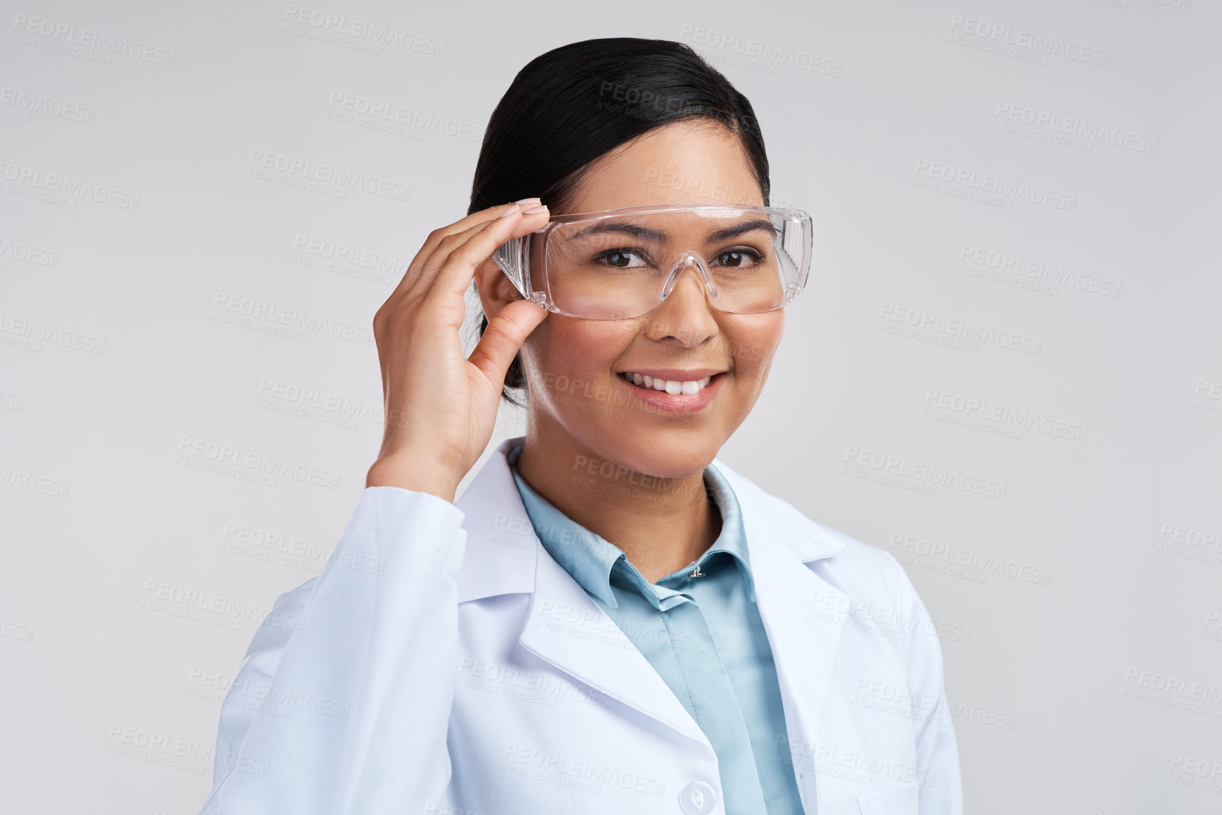 Buy stock photo Cropped portrait of an attractive young female scientist wearing goggles in studio against a grey background