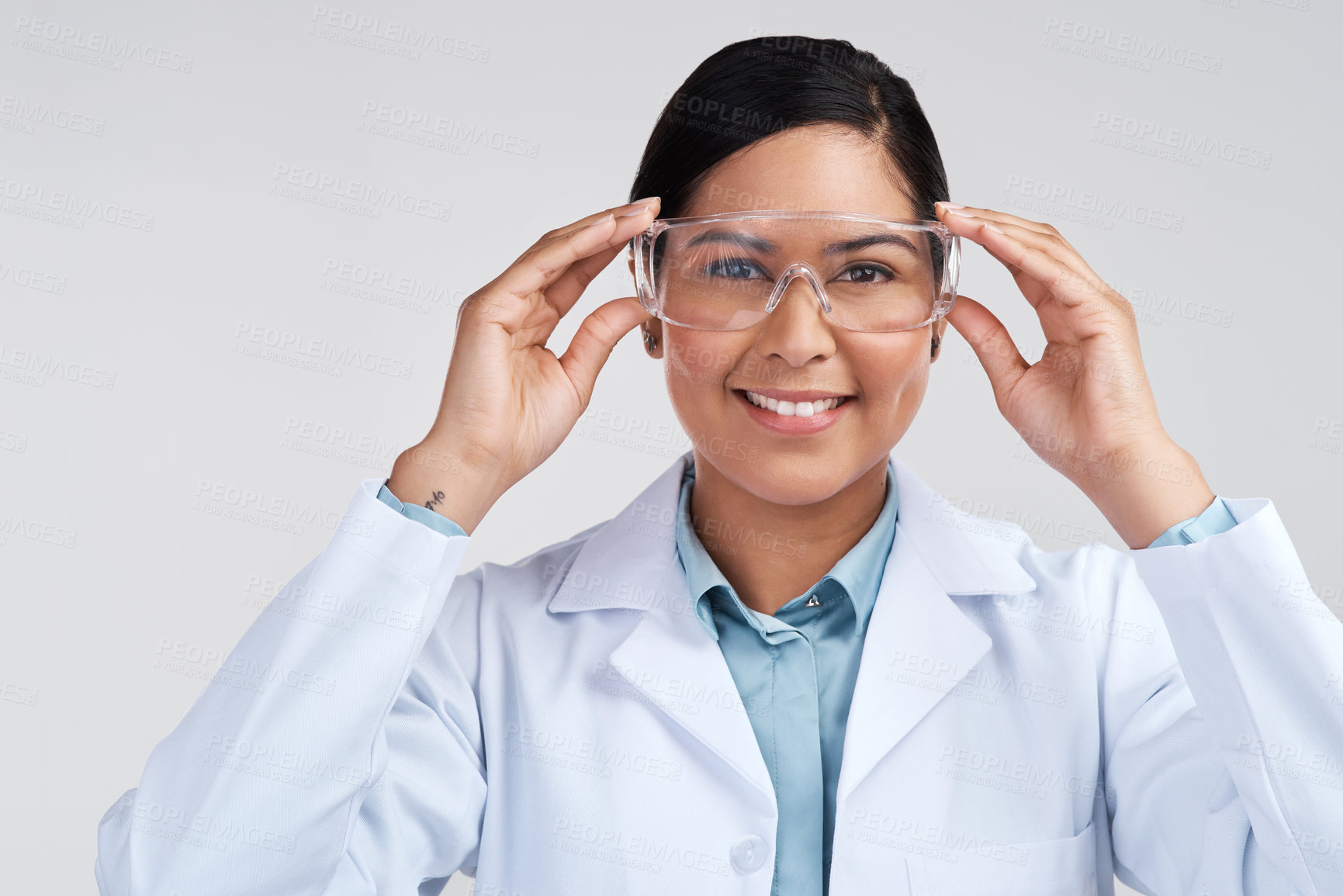 Buy stock photo Cropped portrait of an attractive young female scientist wearing goggles in studio against a grey background