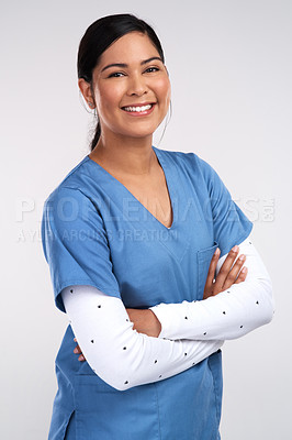 Buy stock photo Portrait of a beautiful young doctor standing with arms folded against a white background