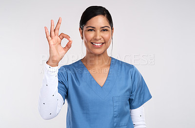 Buy stock photo Portrait of a young doctor showing the ok sign against a white background