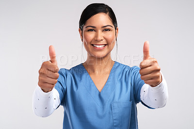 Buy stock photo Portrait of a young doctor showing a thumbs up sign against a white background