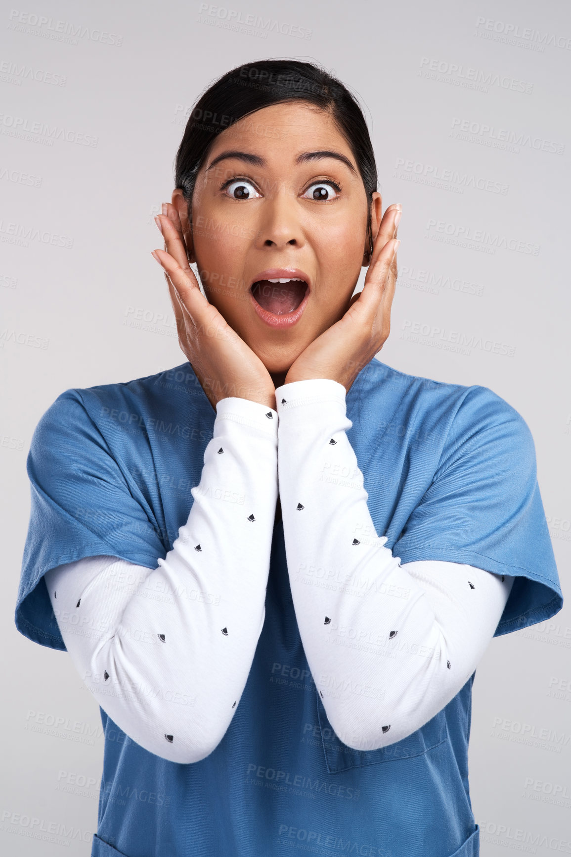 Buy stock photo Portrait of a shocked young doctor in scrubs against a white background