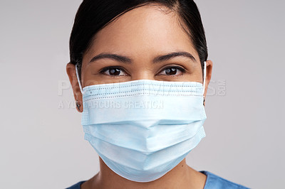 Buy stock photo Portrait of a young doctor wearing a surgical face mask against a white background