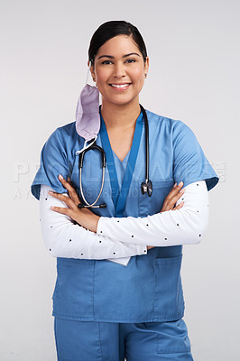 Buy stock photo Portrait of a young doctor folding her arms and wearing a stethoscope against a white background