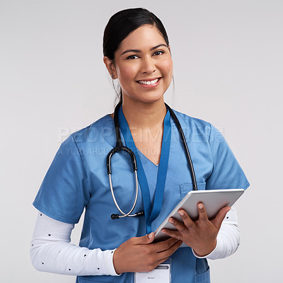 Buy stock photo Portrait of a young doctor using a tablet and wearing a stethoscope against a white background