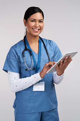 Buy stock photo Portrait of a young doctor using a tablet and wearing a stethoscope against a white background