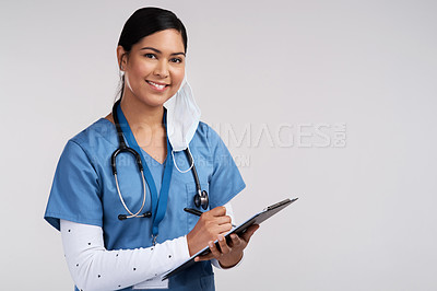 Buy stock photo Portrait of a young doctor wearing a stethoscope and making notes on a clipboard against a white background