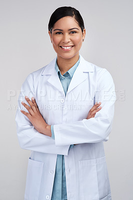 Buy stock photo Cropped portrait of an attractive young female scientist standing with her arms folded in studio against a grey background