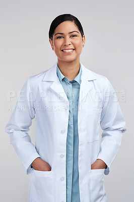 Buy stock photo Cropped portrait of an attractive young female scientist standing with her hands in her pockets in studio against a grey background