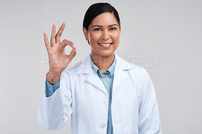 Buy stock photo Cropped portrait of an attractive young female scientist gesturing a-okay in studio against a grey background