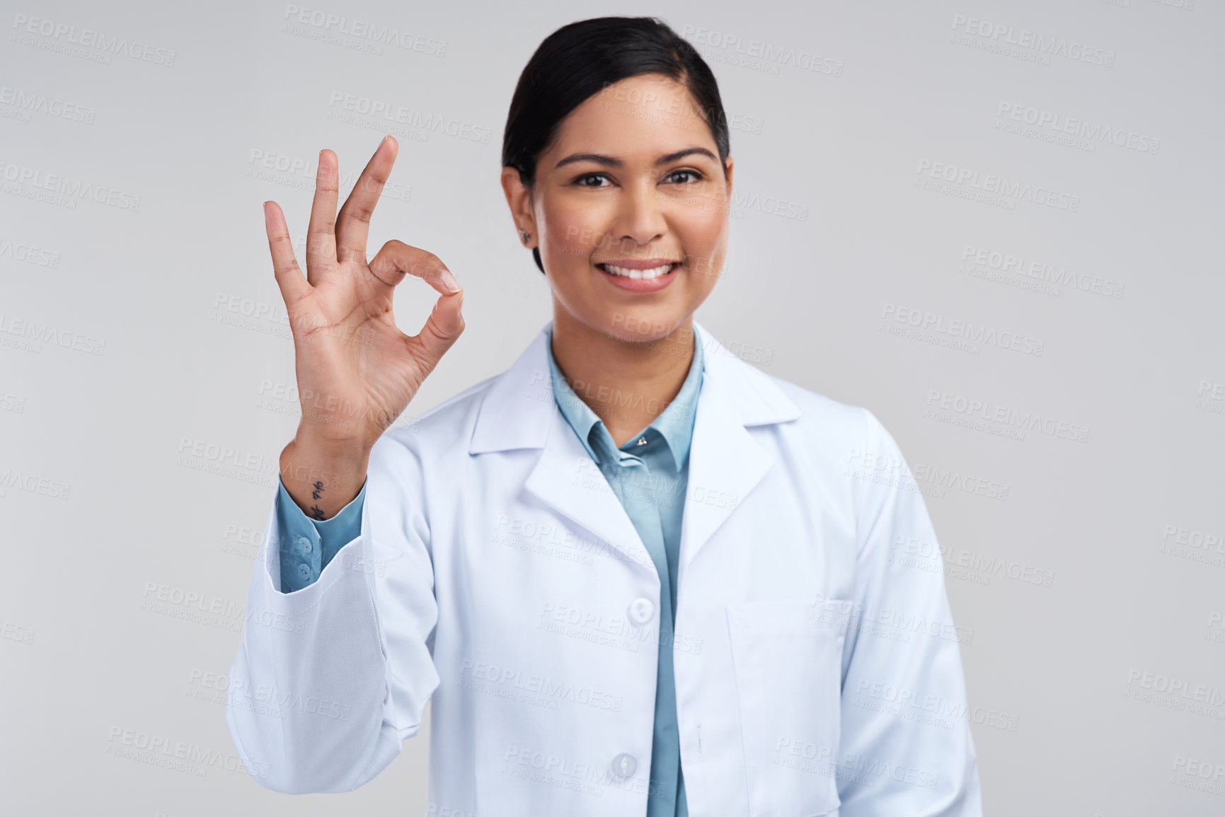 Buy stock photo Cropped portrait of an attractive young female scientist gesturing a-okay in studio against a grey background