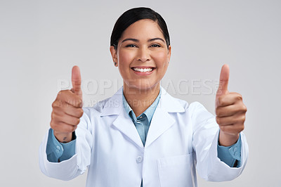 Buy stock photo Cropped portrait of an attractive young female scientist gesturing thumbs up in studio against a grey background