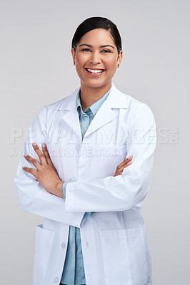 Buy stock photo Cropped portrait of an attractive young female scientist standing with her arms folded in studio against a grey background