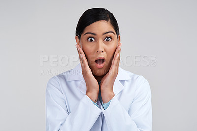 Buy stock photo Cropped portrait of an attractive young female scientist looking shocked in studio against a grey background